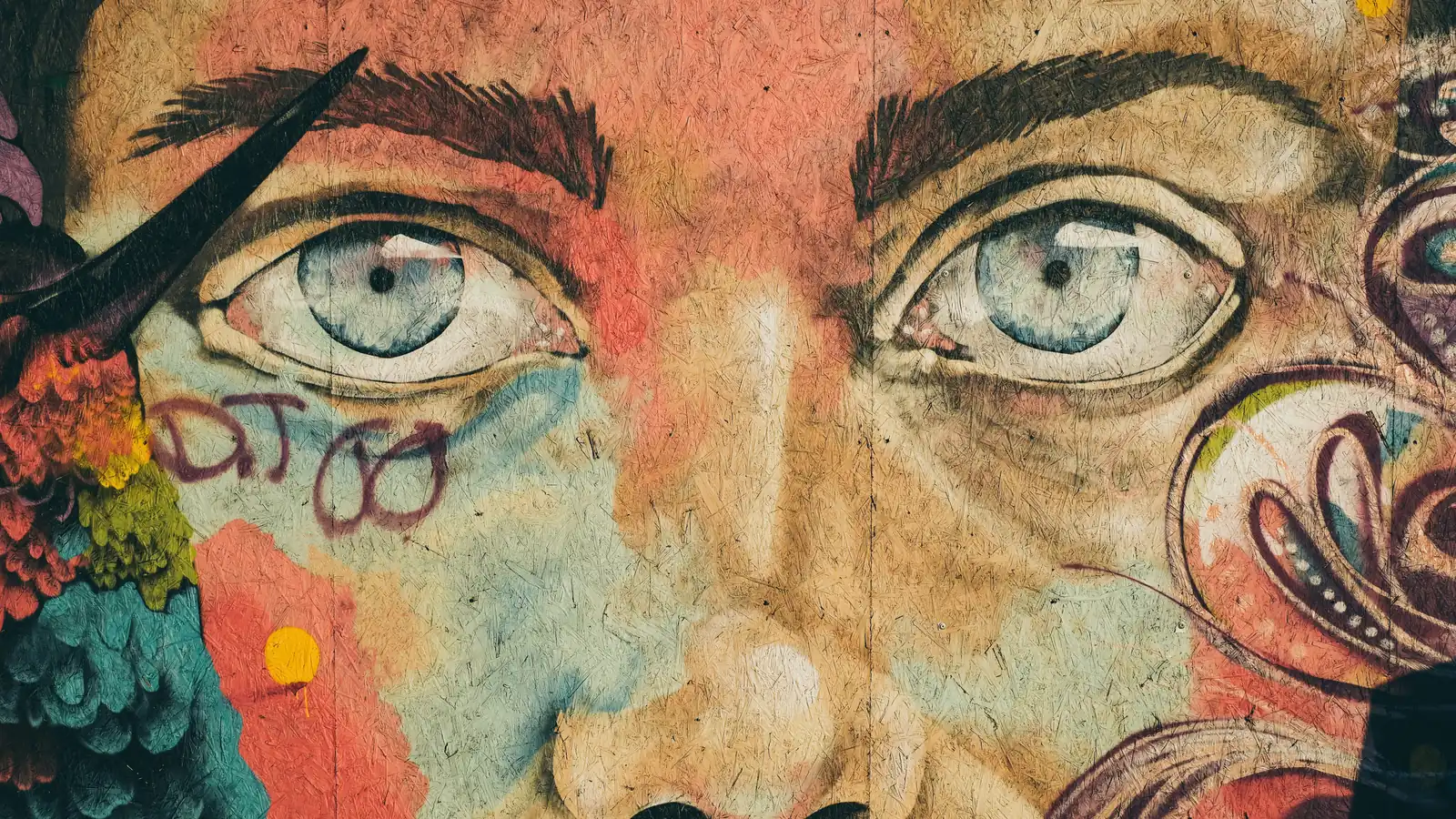 A mural of a face with large blue eyes looking straight at the viewer