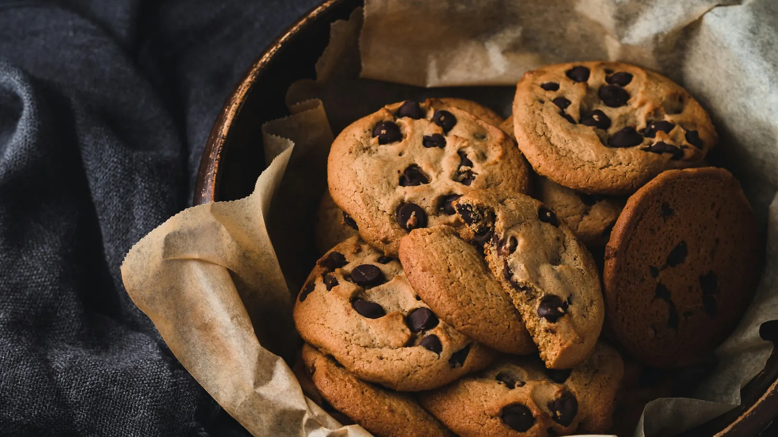A bowl of chocolate cookies on a table in warm light